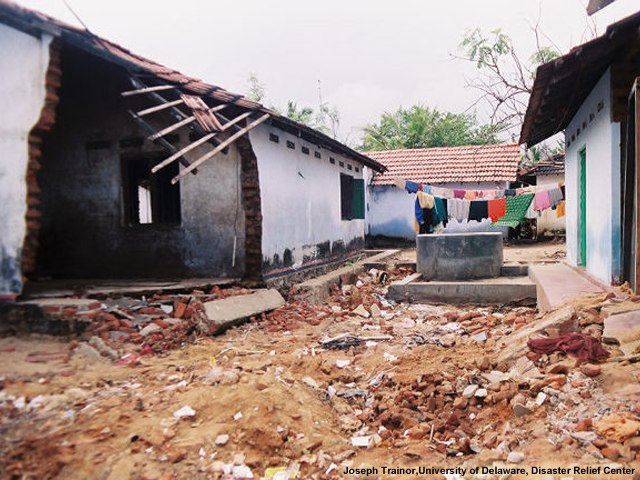 Destroyed houses, a well, and laundry in Sri Lanka after the 2004 Indian Ocean Tsunami.